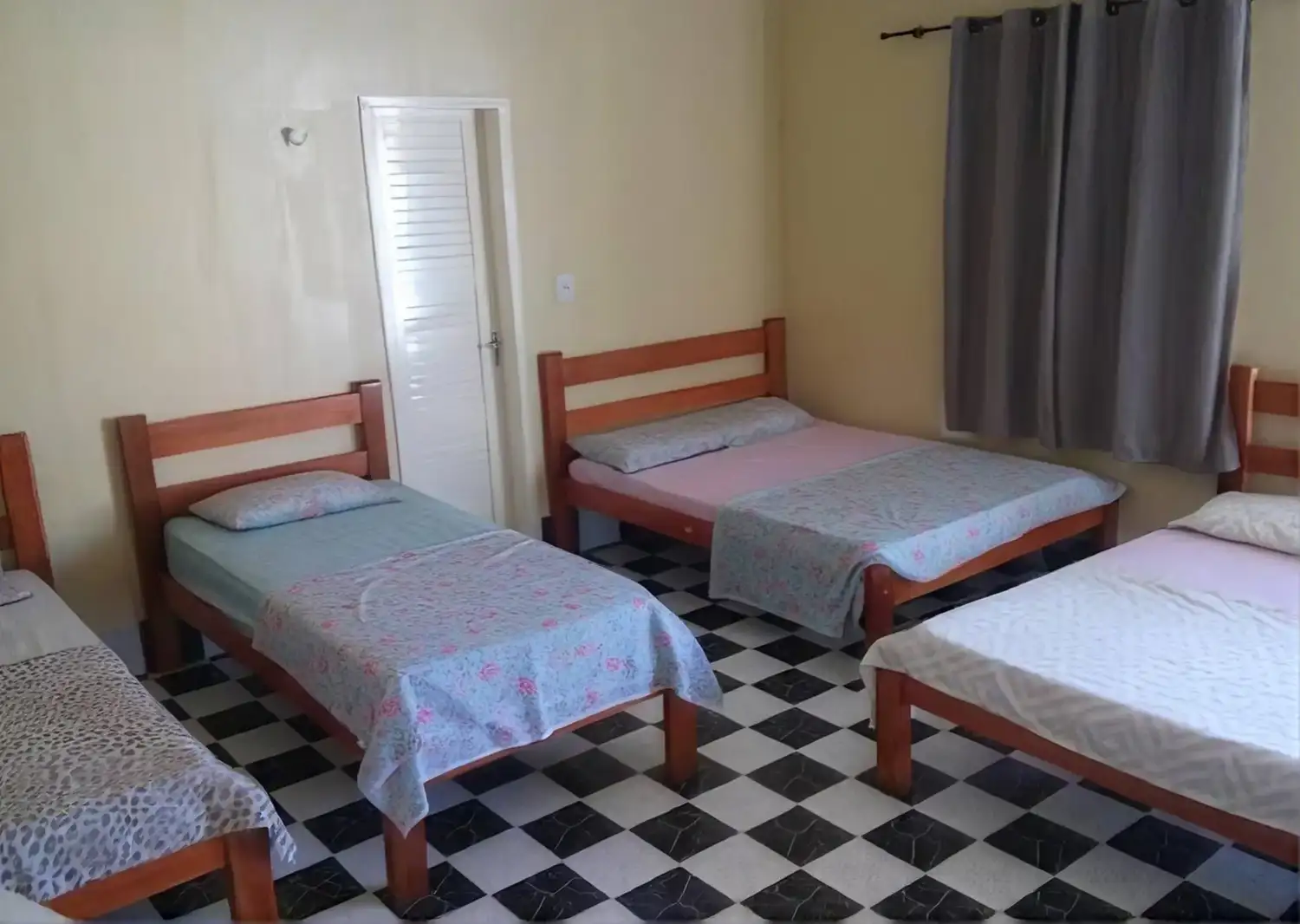 Quarto familiar com quatro camas de solteiro para grupos maiores